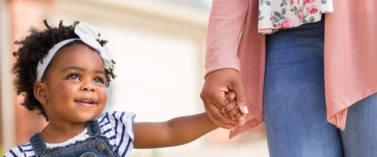 22 month old girl holding mom's hand