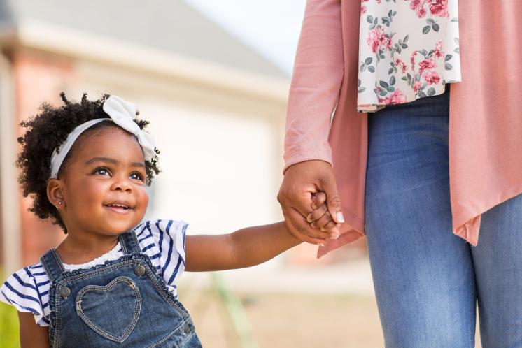 22 month old girl holding mom's hand