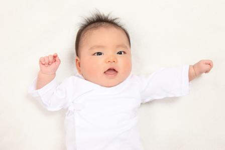 2 month old baby in a white outfit with white background