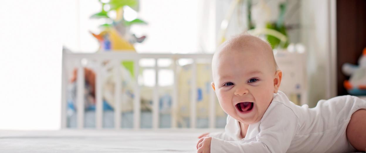 4 month old smiling at camera while doing tummy time
