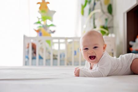 4 month old smiling at camera while doing tummy time