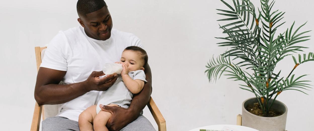 Dad rocking baby while offering a feeding before bedtime
