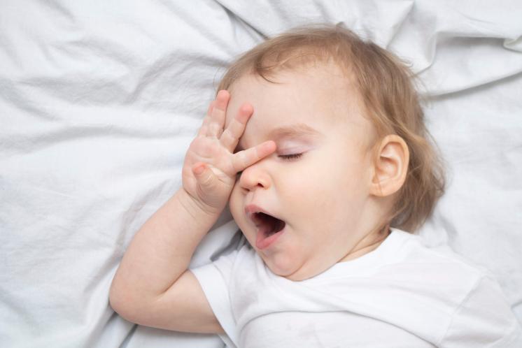 baby yawning and rubbing eyes