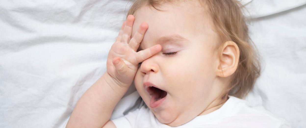 baby yawning and rubbing eyes
