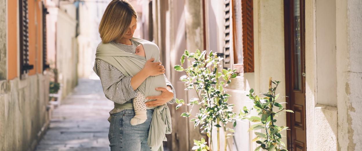 Baby napping while mom is babywearing outside during a walk