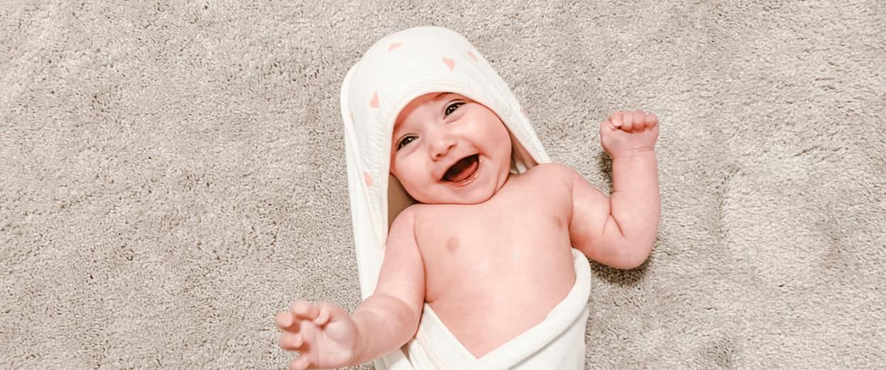 baby wrapped in towel after bathtime before bedtime