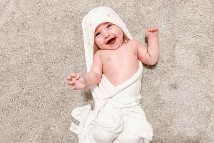 baby wrapped in towel after bathtime before bedtime