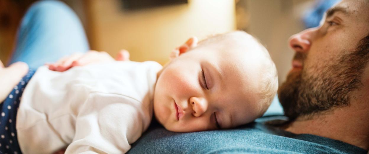 Baby girl napping on dad's chest