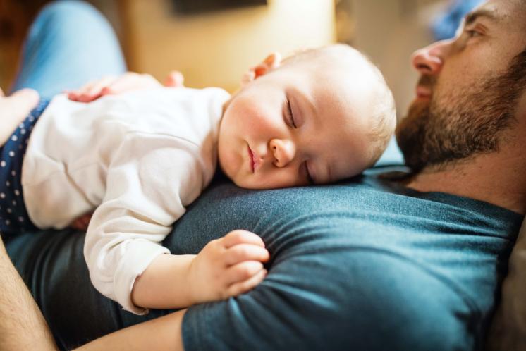 Baby girl napping on dad's chest