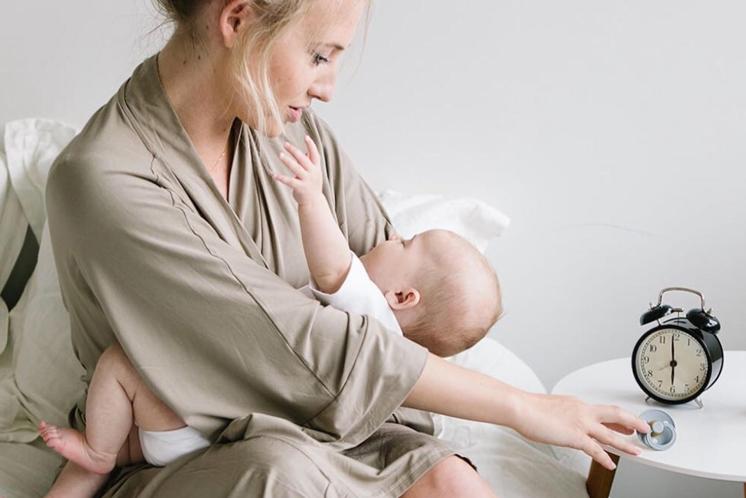 mom looking at baby wondering why she is up so early after daylight savings