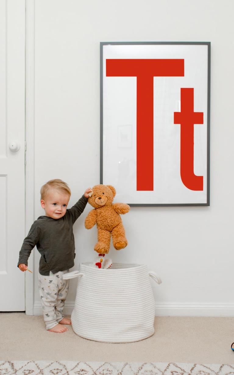 toddler putting stuffed bear into a toy basket