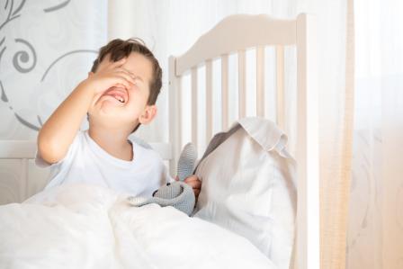 toddler boy in bed protesting bedtime
