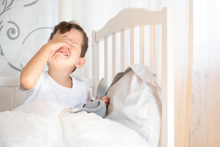 toddler boy in bed protesting bedtime