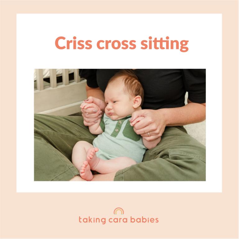 newborn baby sitting in adult's lap