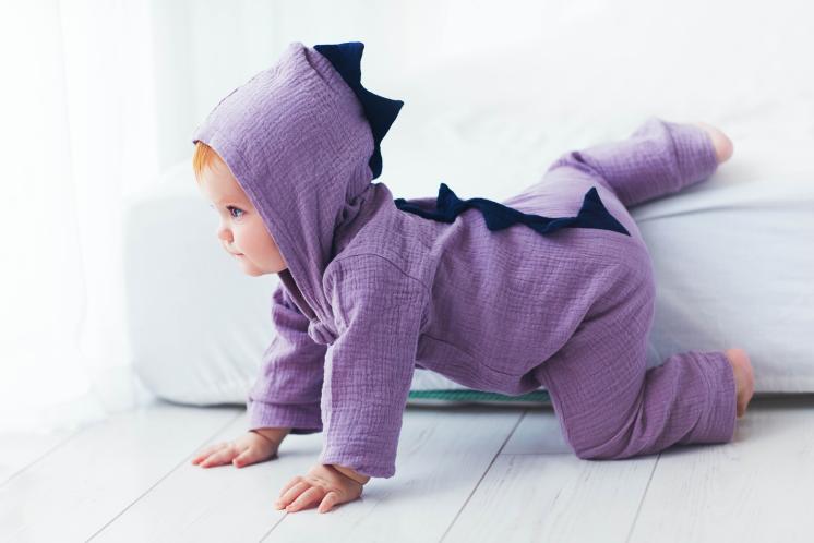 baby crawling across floor in purple monster costume