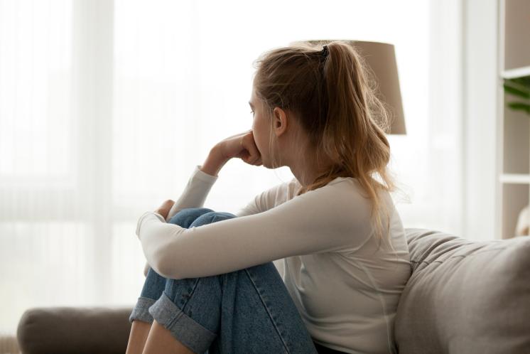 woman sitting with hand on chin and looking out the window