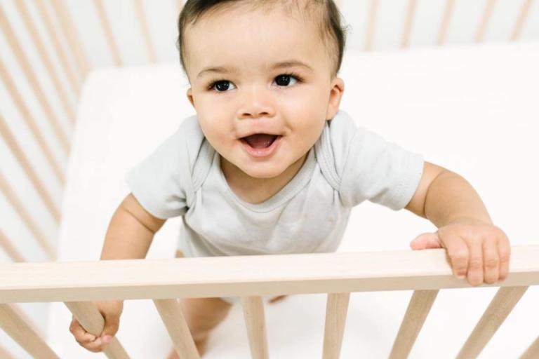 baby standing in crib for safe sleep