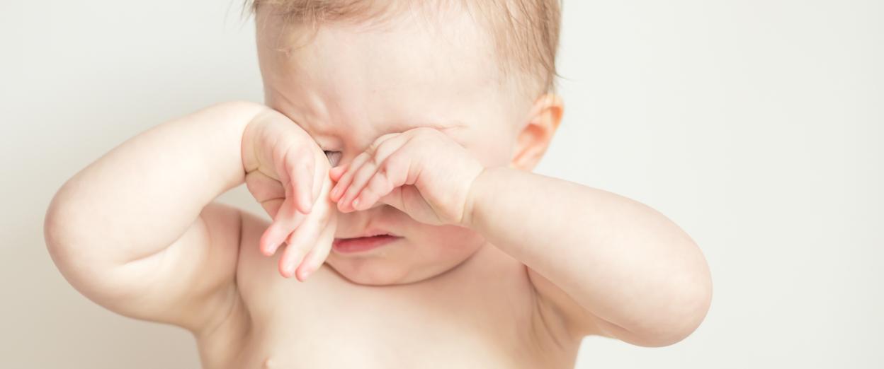 tired baby rubbing their eyes