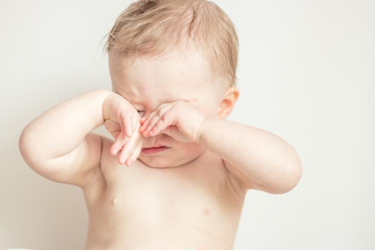 tired baby rubbing their eyes