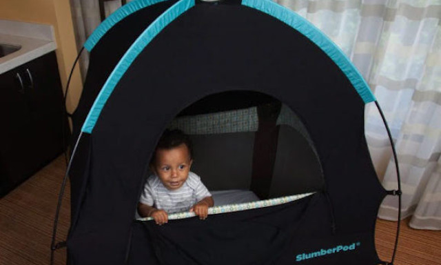 Slumbered with toddler standing up looking out from pack n play