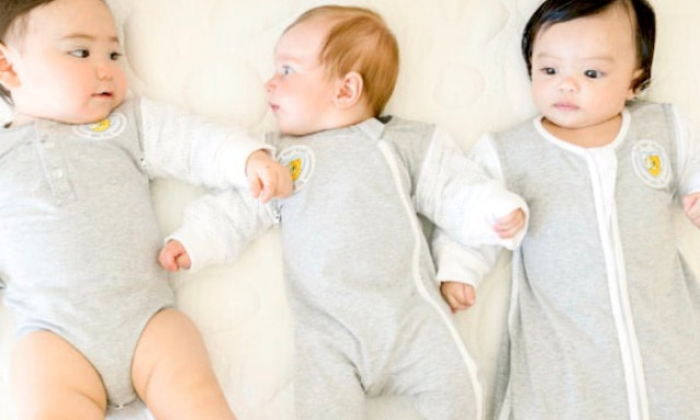 three babies wearing different swaddle sleeve products