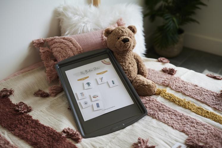 magnetic bedtime routine chart on bed with teddy bear